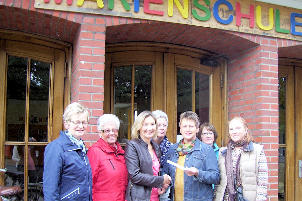 Petra Jokiel (dritte von links), Leiterin der Aktion Gänseblümchen, überreicht das Geld an Maria Gesing, Leiterin der Carlo-Gruppe.